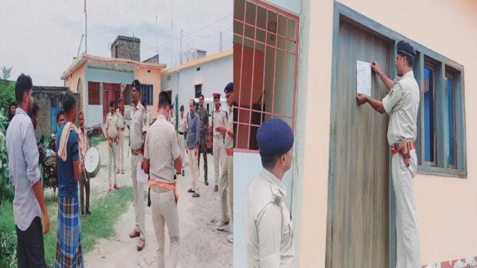 हत्या में फरार अभियुक्त के घर पुलिस ने चिपकाया इश्तेहार