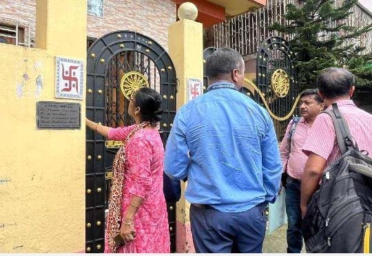 कोलकाता के बेलियाघाटा स्थित डॉ. संदीप घोष के घर पर गेट खुलवाने को कॉल बेल बजातीं सीबीआई की महिला अधिकारी।