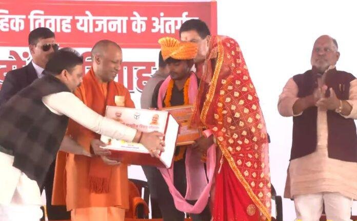 सामूहिक विवाह कार्यक्रम-min सीएम योगी विवाहित जोड़ों को विवाह प्रमाण पत्र और उपहार प्रदान करते हुए