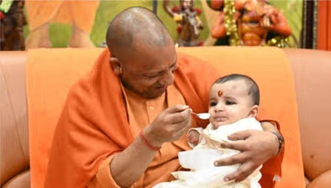 मकर  संक्रांति पर गोरखपुर में गोरक्ष पीठ में एक बालक का अन्नप्रासन कराते हुएसीएम योगी आदित्यनाथ। 